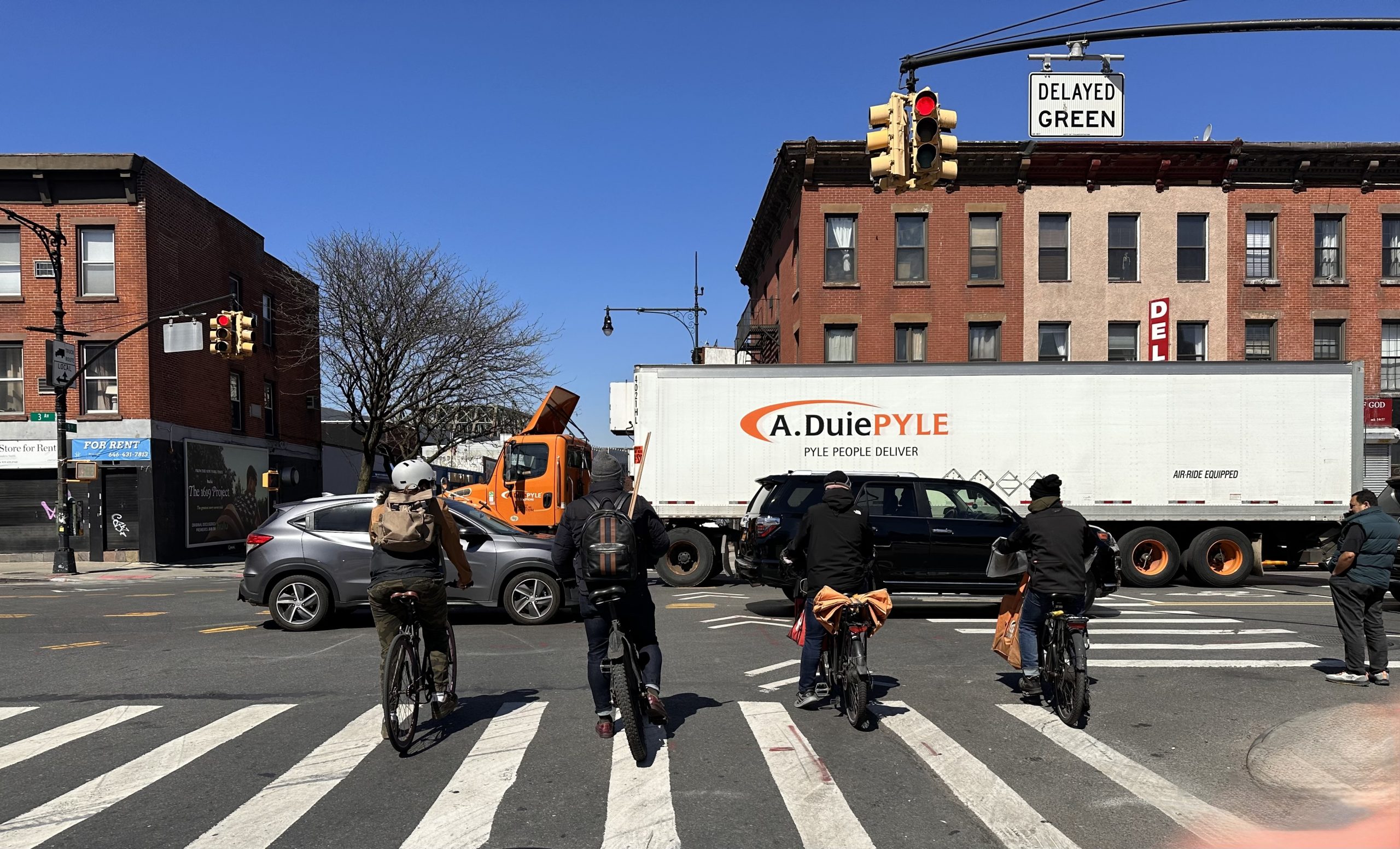 Four people on bicycles wait for the light to turn green at an intersection, where rules are often unclear.
