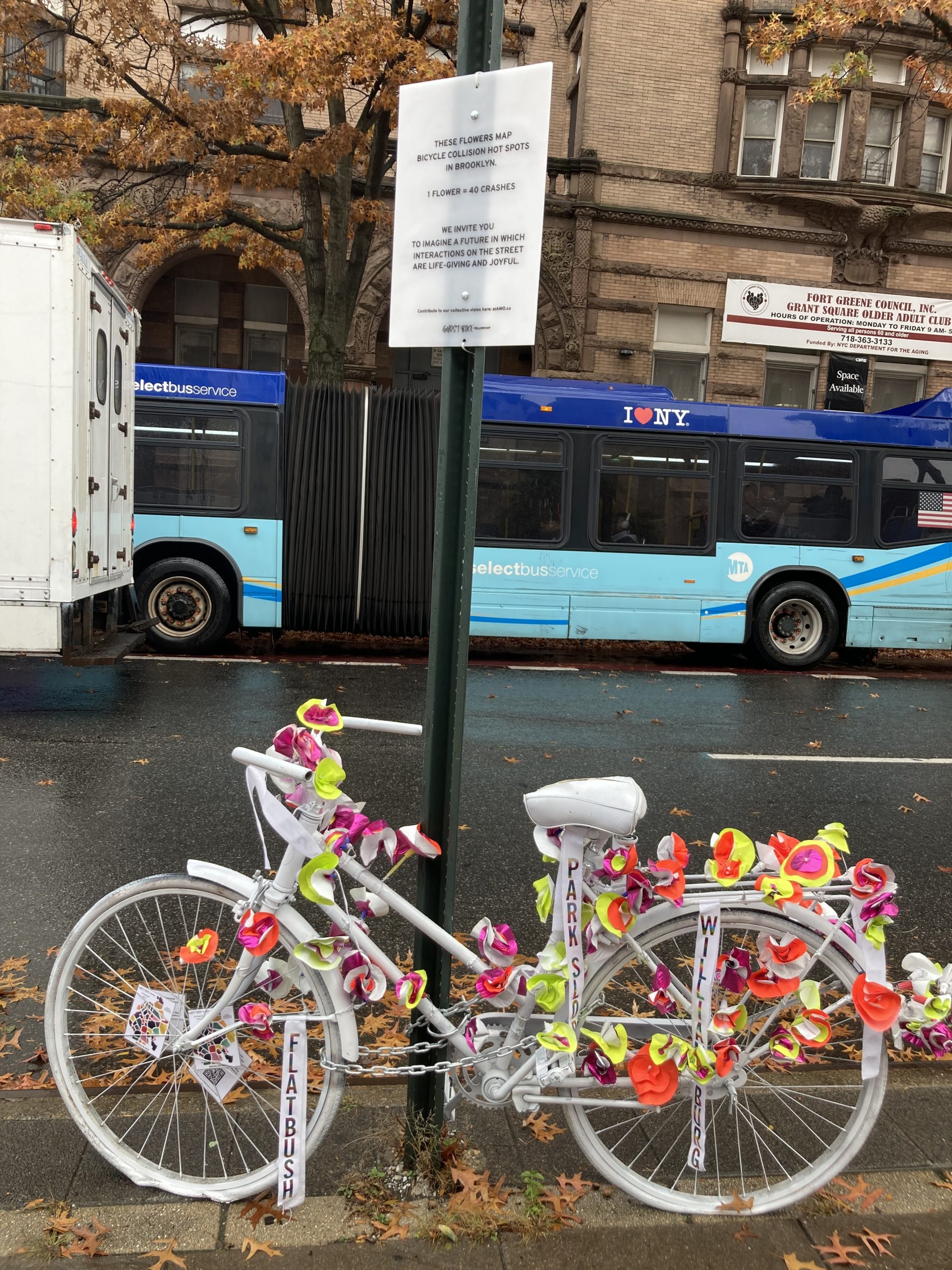 Ghost bike with flowers locked to a pole