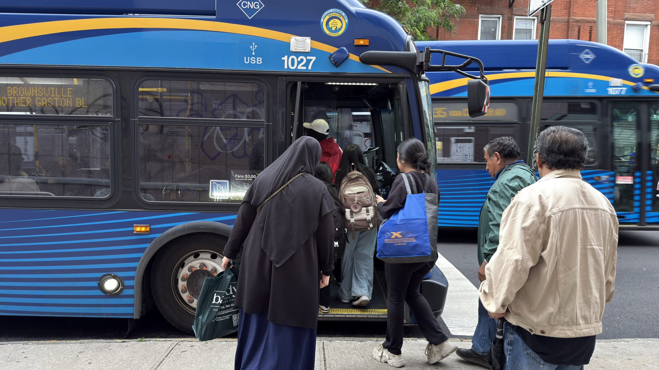 A line of people entering the bus in New York City